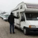 Tweedehands camper op een occasionterrein terwijl kopers de gebruikte campermarkt vergelijken.